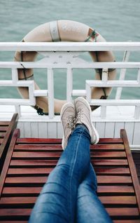 Low section of man sitting in ship at sea