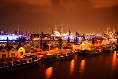 Boats moored in harbor at night