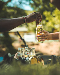 Close-up of hand holding glass bottle against blurred background