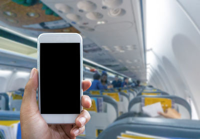 Close-up of person using mobile phone in bus