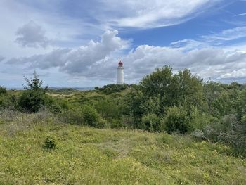 Lighthouse on field against sky