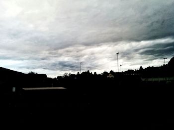 Silhouette built structure against cloudy sky