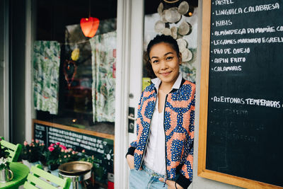 Portrait of smiling young woman standing in store