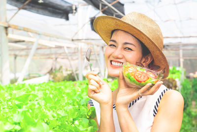 Portrait of smiling young woman holding hat