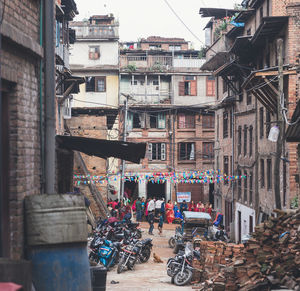 People on street amidst buildings in city