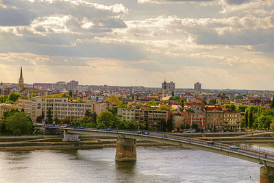 Bridge over river in city against sky