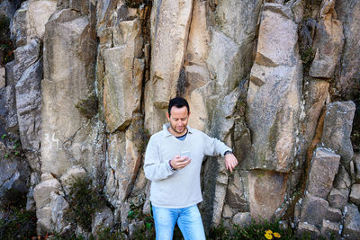 Portrait of smiling man standing on rock