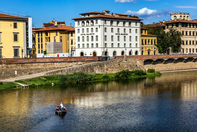 People in river against buildings