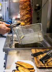 Cropped hands of man preparing food in kitchen