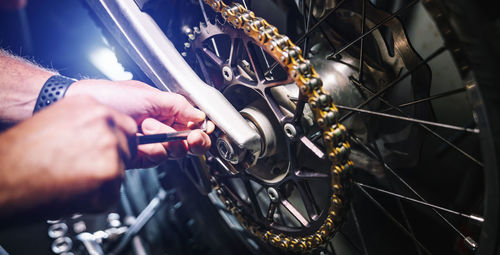 Midsection of man working with bicycle