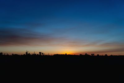 Silhouette landscape against dramatic sky during sunset