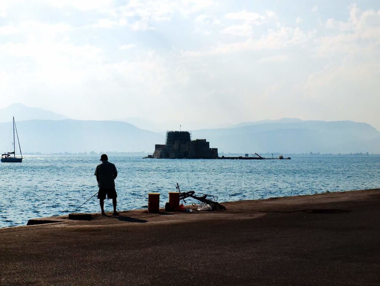 sea, water, one person, real people, sky, full length, men, rear view, nature, outdoors, leisure activity, day, lifestyles, built structure, standing, scenics, beauty in nature, architecture, beach, building exterior, nautical vessel, one man only, adult, people