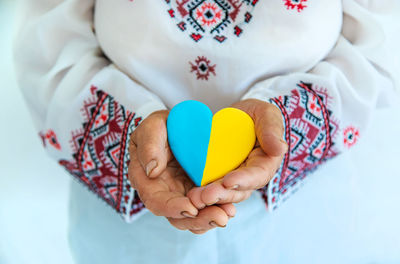 Midsection of woman holding heart shape candy