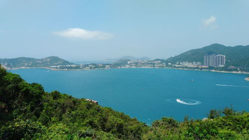 Scenic view of sea and cityscape against sky