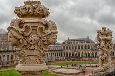 Statue of statues against cloudy sky