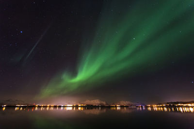 Scenic view of sea against aurora borealis at night