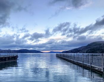 View of pier on sea against cloudy sky