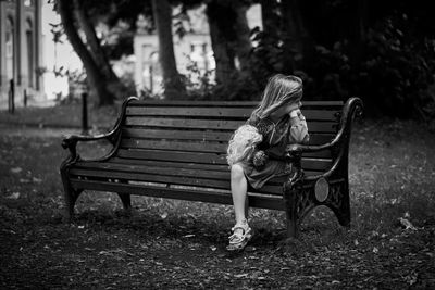 Boy sitting on bench in park