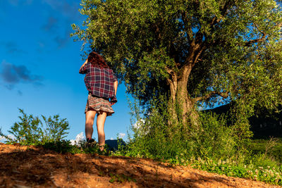 Rear view of woman standing by plants