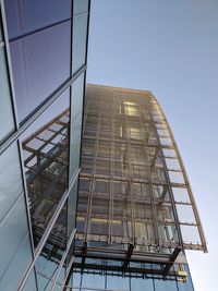 Low angle view of glass building against clear sky