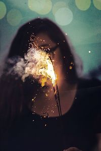 Close-up of woman playing with sparklers