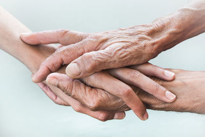 Cropped image of senior people stacking hands outdoors