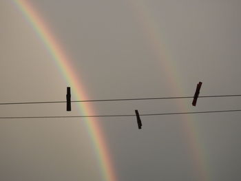 Low angle view of silhouette cables against sky during sunset