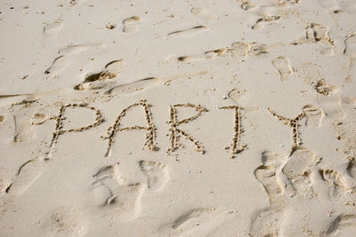 Full frame shot of sand with party text