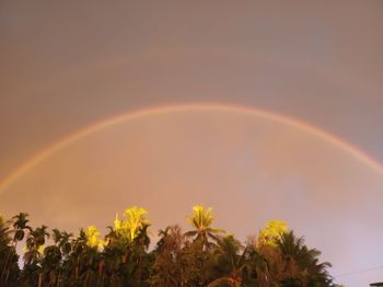 Low angle view of rainbow against sky at sunset