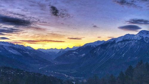 Scenic view of snowcapped mountains against sky during sunset