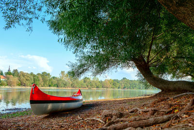 Boat moored on riverbank against sky