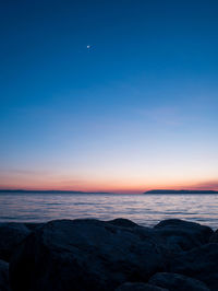 Scenic view of sea against clear sky at sunset