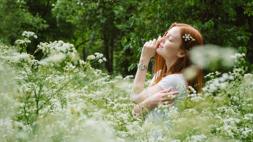 Woman standing by flowering plants