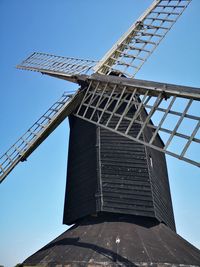 Low angle view of traditional windmill against clear blue sky