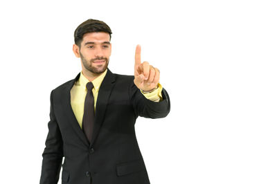 Portrait of young man standing against white background