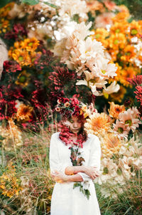 Woman standing by flowering plants