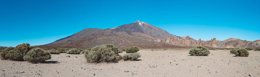 Scenic view of desert against clear blue sky