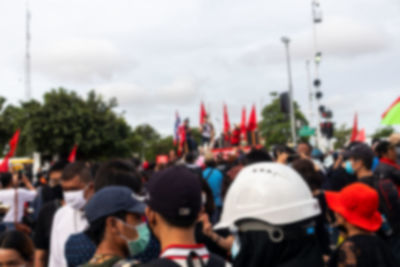 Rear view of people on street against sky