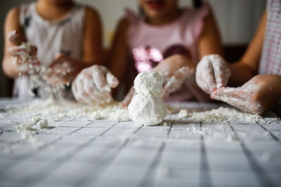 Funny children play with artificial snow at home in kitchen. sensory development and games at home