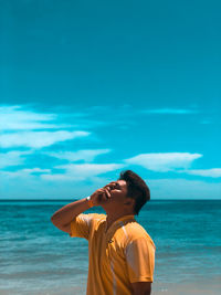 Man standing at beach against sky