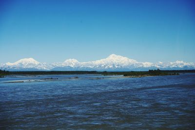 Scenic view of snowcapped mountains against cloudy sky