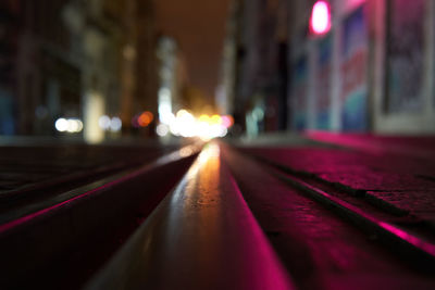 Illuminated railroad tracks in city at night