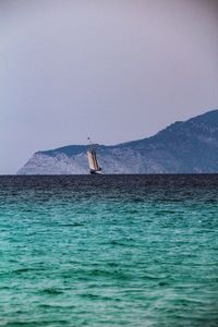 Sailboat in sea against clear sky