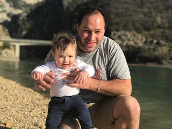 Portrait of father with son on shore at beach