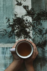 Directly above shot of hand holding coffee cup