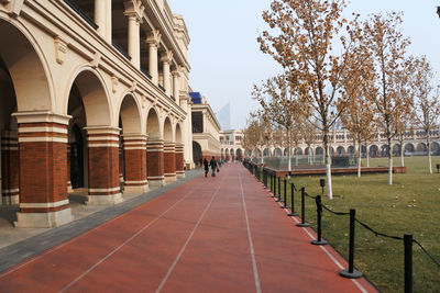 Walkway by building against sky