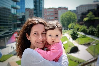 Portrait of mother and daughter in city