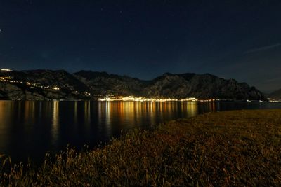 Scenic view of lake against sky at night