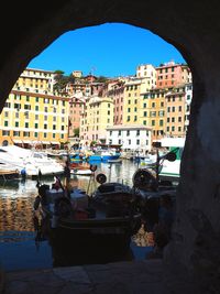 Boats in canal amidst buildings in city