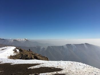 Scenic view of snowcapped mountains against clear blue sky